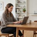Person bruger VPN derhjemme på laptop foran en router i moderne stue